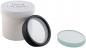 Preview: The image shows a white container with a screw top. Next to the container, there are two lenses: a clear lens with a black rim and a flat, green lens.