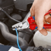 Preview: A hand holds red pliers that are gripping a blue wire. In the background, auto parts and hoses are visible. The pliers have a metallic blade and a non-slip grip area.