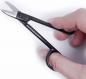 Preview: The image shows a hand holding a small, black pair of scissors. The tips of the scissors are curved and sharp. The handles are ergonomically designed and easy to grip.