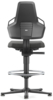 Preview: The image shows a modern office chair from the back. It has a high backrest, armrests, and a padded seat. A round footrest is visible underneath. The chair has wheels and is black.