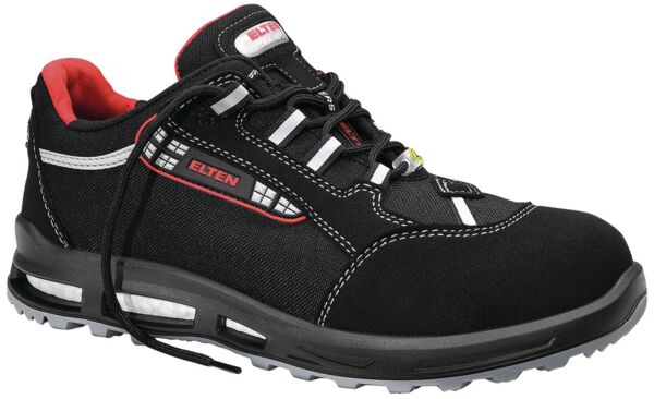 The shoe is a sporty safety shoe. It is predominantly black with red and white accents. The laces are black, and the sole is slip-resistant and sturdy.