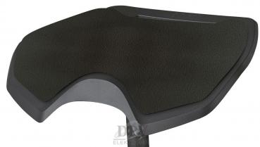 The image shows an ergonomic seat in the form of a slightly wavy, wide cushion. The surface is dark and textured, and the cushion has rounded edges.