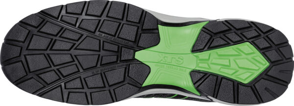 The image shows the underside of a sports shoe with a highly textured tread. The sole is predominantly black, with a green insert shaped like an X in the center.