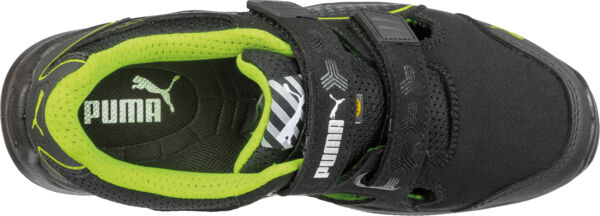 The image shows a black sports shoe with a green insole. The shoe features a wide Velcro strap and a sporty design. The Puma logo is clearly visible.