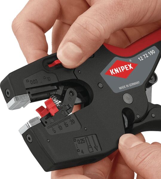 Das Bild zeigt eine Hand, die eine Abisolierzange von Knipex hält. Die Zange hat eine schwarze Oberfläche mit roten Akzenten und verschiedenen Einstellmarkierungen.