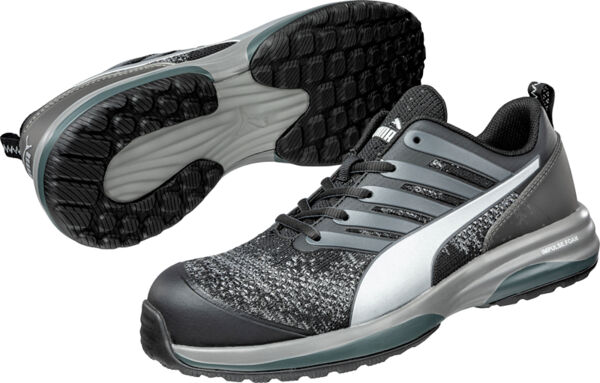 The image shows a pair of black athletic shoes with reflective silver accents. They feature a textured sole for better grip and laces on the top.