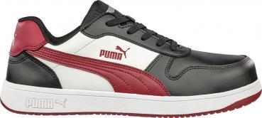 Der Schuh ist ein sportlicher Sneaker mit schwarzem Obermaterial, weißen Akzenten und roten Details. Er hat eine flache Sohle und eine klassische Schnürung. Das Puma-Logo ist sichtbar.