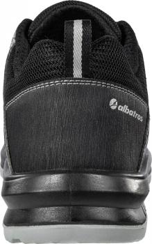 The image shows the back of a black sports shoe. It has a simple design with a gray stripe in the middle and a small logo on the side. The sole is slightly transparent.