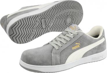 The image shows gray sneakers made of soft material with a white side panel and gold details. They have a flat, textured sole and multiple shoelaces.