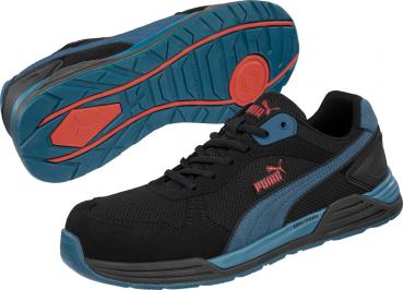 In the picture, there are black sports shoes with blue and red accents visible. They feature a sporty design, a grippy sole, and flexible materials for comfort.