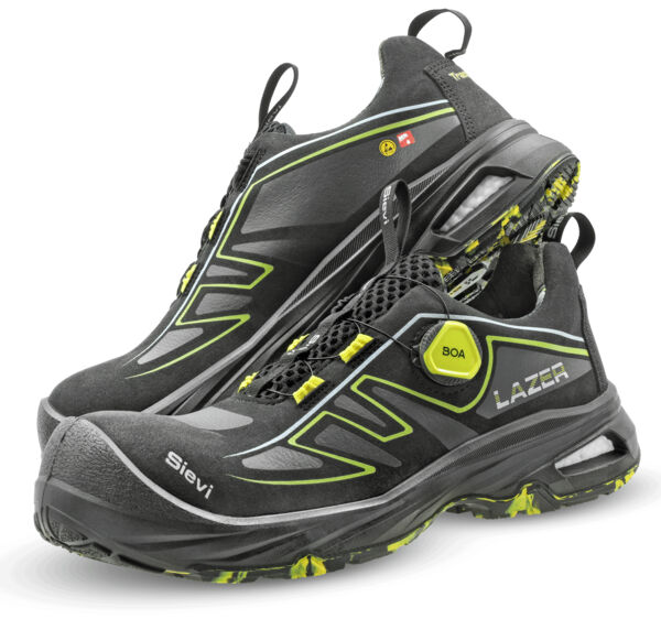 The image shows a pair of black sports shoes with yellow accents. They have a modern shape, are straightforward, and feature a grippy sole with a sturdy, breathable material.