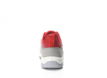 The image shows the rear view of a sports shoe. It is gray with red accents and has a light sole. The shoe has a rounded shape and appears modern and sporty.