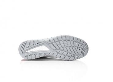 The image shows the underside of a gray sports shoe. The sole features a textured pattern with grooves and studs for better grip. The background is neutral and bright.