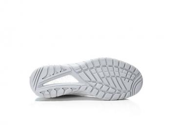 The image displays the sole of a white sports shoe. The sole features a textured pattern with grooves and studs that provide grip and traction.