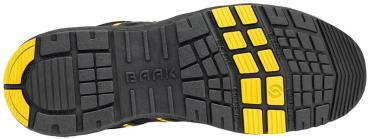 The image displays the sole of a sports shoe featuring a non-slip, textured pattern. The sole is predominantly black with yellow details that provide additional grip.