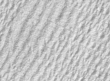 The image shows a bright, textured surface with gentle, wavy lines. The texture resembles fine sand or a smooth, even surface.