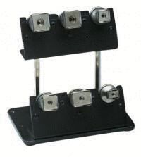 The image shows a black, sturdy stand with four silver coils arranged in two rows. Each coil has a small opening in the center.