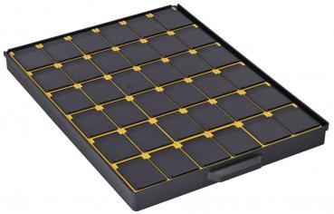 The image shows a black plastic box with 25 square compartments separated by yellow frames. The compartments are evenly arranged and flat.