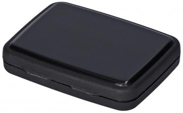 The image shows a flat, rectangular object in black. It has rounded corners and a smooth surface. It could be a small box or a packaging.