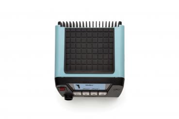 The image shows a compact device in blue and black colors. It has a square, non-slip surface with many small bumps and several buttons and knobs on the front.