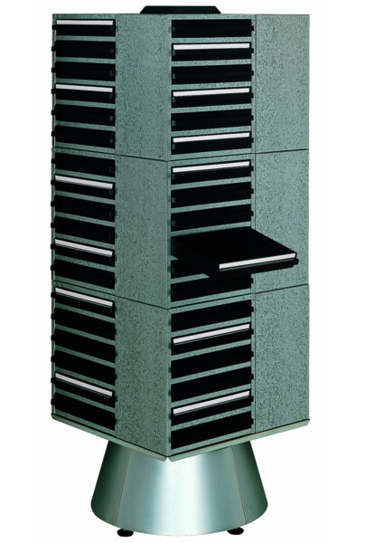 The image shows a tall, vertical dresser with several black drawers. The dresser has a gray, textured surface and stands on a round, silver base.