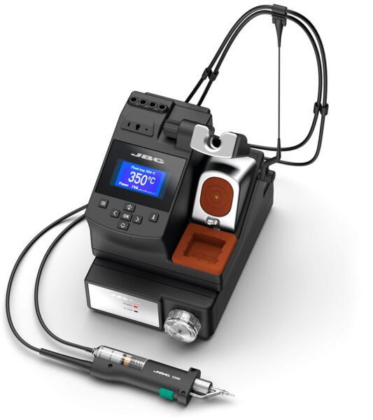 The image shows a compact, black device with a digital display and buttons. It features an attachment for fine work and a hose connected to a handpiece.