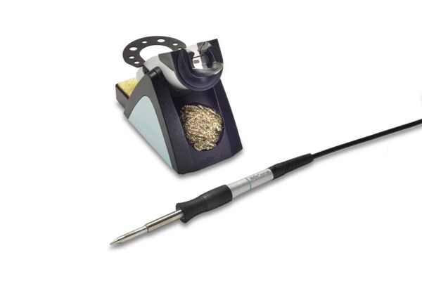 The image displays a soldering iron with an electrical cable and a soldering device. The device has a rectangular base with a metal layer for resting the soldering iron, and a collection tray with metal shavings.