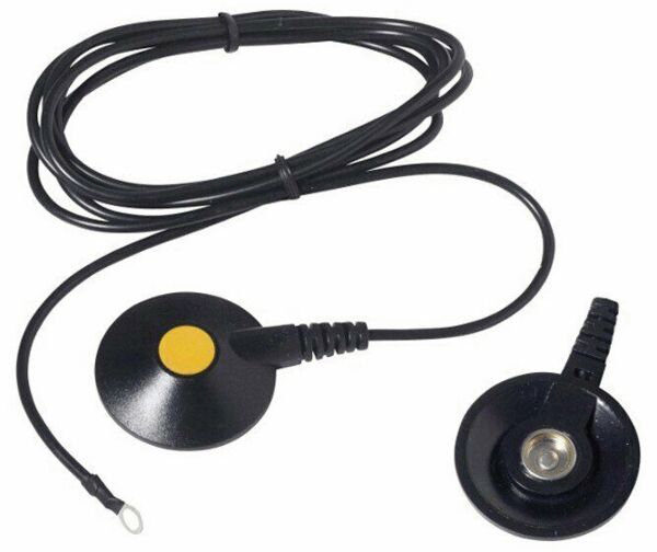 The image shows an electrical component with two round discs: one with a yellow dot and one without. They are connected by a long, black cable.