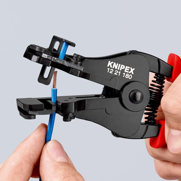 Das Bild zeigt einen elektrischen Kabelschneider in einer Hand. Der Schneider ist schwarz mit roten Griffen und hält ein blaues Kabel. Auf dem Werkzeug steht "KNIPEX".