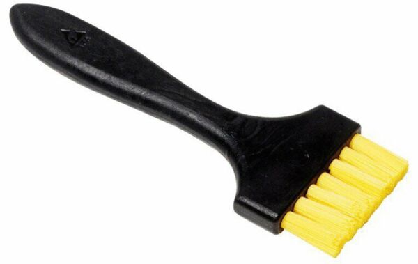 The image shows a brush with a black handle and yellow bristles. The bristles are arranged in a row and the handle is slightly curved to provide a good grip.