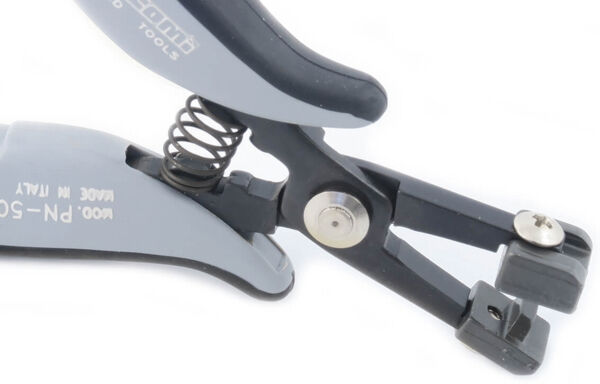 The image shows a gray pair of pliers with a black handle. It has a spring and a special device for gripping or cutting materials. The head is narrow and precise.