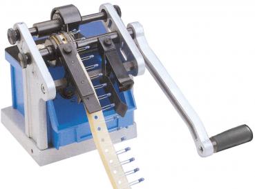 The image shows a manual machine with a long lever and a blue box. The machine has various teeth and a roller for processing material.