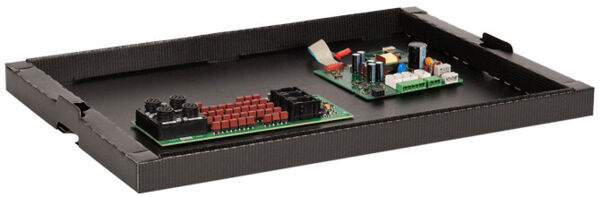 The image shows a flat black tray with two circuit boards. One board has many small red components, the other is more colorful with various electrical components.