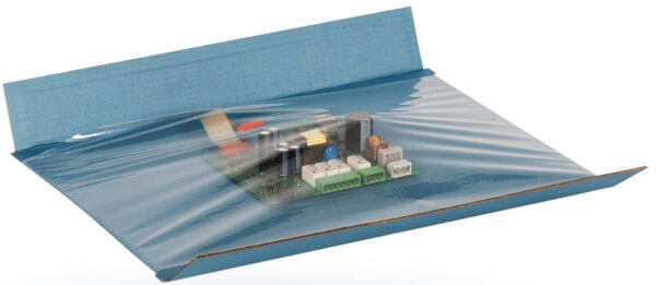 The image shows an electronic circuit board packaged in a transparent film. It is placed on a blue cardboard that is slightly wavy on the right and left sides.