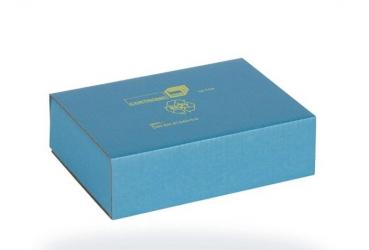 The image shows a square, turquoise cardboard packaging. On the top, there are some symbols and text printed in yellow. The box appears simple and modern.