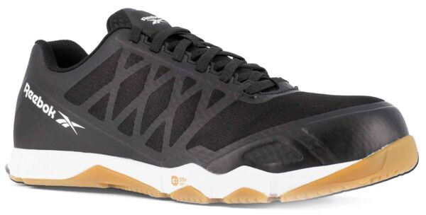 The shoe is a sporty sneaker in black with a sturdy, slightly shiny front part. The sole is white with a brown rubber area. It has a modern, lace-up shape.