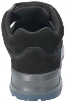 The image shows the rear view of a black sports shoe. The shoe has a soft, velvety surface and a gray, textured sole. The shaft is slightly raised and has a curved edge.