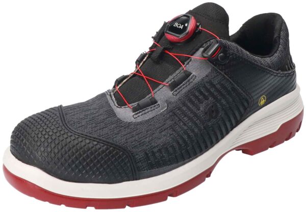 The shoe is black with gray and red accents. It has a textured upper and a sturdy sole. A BOA closure system ensures an easy fit. Ideal for work and leisure.