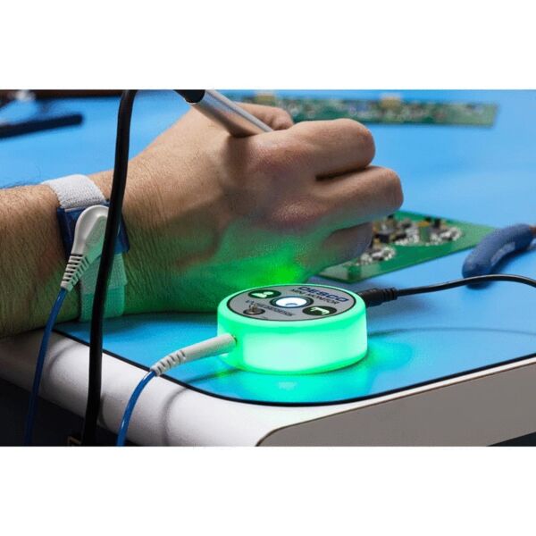 A section featuring a hand holding a soldering tip, while a green, glowing, circular device is on the table. Cables are connected to it, and circuits are visible in the background.