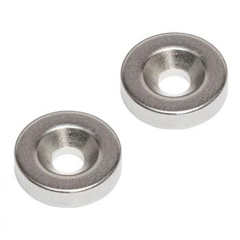 The image shows two flat, round metal discs with a central hole. The surfaces are shiny and reflect light, and the edge is slightly raised.