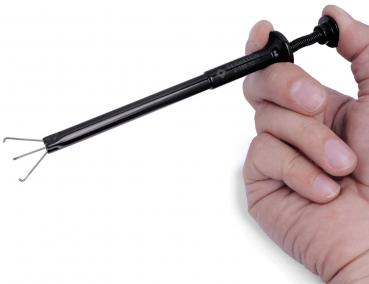 The image shows a handheld black tool aid with a long, slender handle and three curved tips at one end, ideal for precise work in tight spaces.