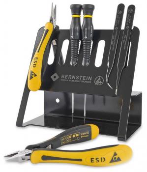 In the picture, various power tools are arranged on a black stand. These include a pair of pliers and several screwdrivers with yellow handles and ESD marking.