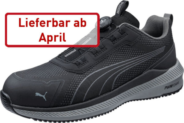 The image shows a black sports shoe with a modern design. It has a textured surface and is equipped with a mesh upper material. On the side is the Puma logo. In red text it says 