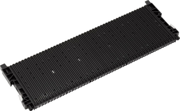 The image shows a long, flat, black heatsink with many fine, parallel grooves. The edges are slightly rounded, and there are brackets at both ends.