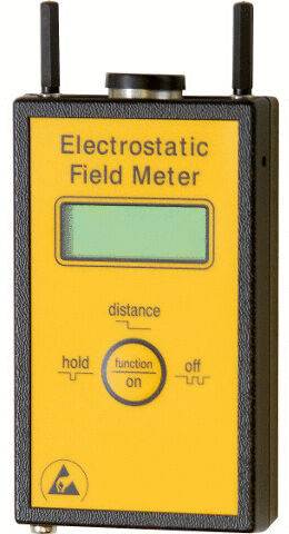 Das Bild zeigt ein elektrostatik Messgerät. Es hat ein gelbes Gehäuse mit einem digitalen Display und Tasten, um Funktionen wie ?hold? und ?on/off? zu steuern. Zwei Antennen sind oben.