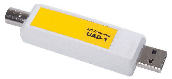 The image shows a white USB adapter with yellow lettering. On one side there is a USB port, and on the other, a round socket.