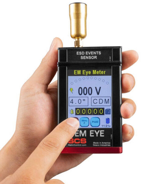 Das Bild zeigt ein Handmessgerät zur Messung von elektrostatischen Entladungen. Es hat einen Bildschirm mit Ziffern und Tasten, eine Antenne oben und wird mit einer Hand gehalten.