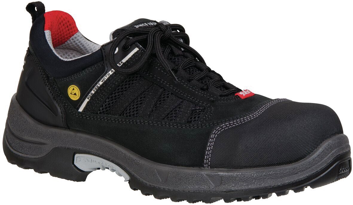 The image shows a black safety shoe with a slip-resistant sole and reinforced toe cap. The shoe has a sporty cut and red details in the lining.