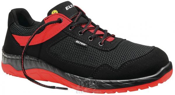 The shoe is lightweight and sporty, predominantly black with red accents. It features a mesh material, laces, and a non-slip sole. Ideal for activities and high comfort.