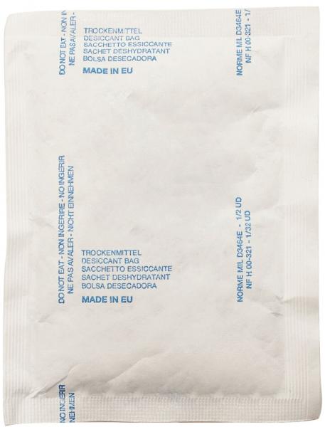 The image shows a white, rectangular pouch. On it, in blue letters, is the word "DESICCANT" along with various languages indicating its function as a moisture absorber.